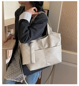 Detail of minimalist beige tote bag with functional outer pocket and matching pouch