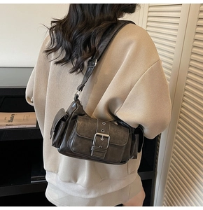 Detail view of a dark grey retro cargo shoulder bag with multiple pockets and matte texture