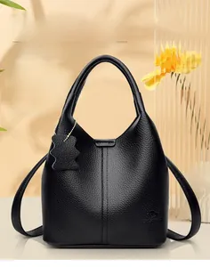 Gros plan sur le cuir grainé noir avec logo kangourou et breloque ours en peluche