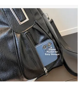 Close-up of a side zipper pocket on a black leather tote bag holding a smartphone for storage