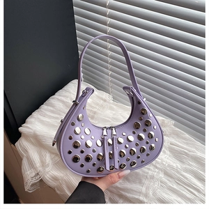 Detail of purple crescent underarm bag featuring decorative silver metal studs