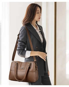 Détail du sac marron en cuir grainé avec logo kangourou argenté et quincaillerie
