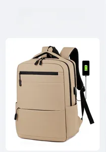 Detail view of khaki business backpack featuring built-in USB charging port and zipper pockets