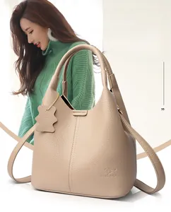 Détails du sac seau beige avec texture grain de litchi et pendentif ours