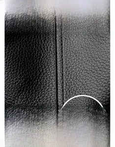 Détail du cuir texturé noir avec logo kangourou et marquage de marque embossé