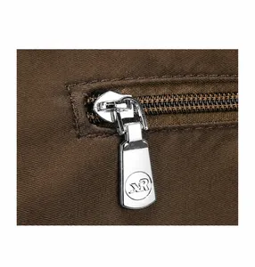 Gedetailleerde macro-opname van de zilveren metalen rits en bruine textuurstof van de tas