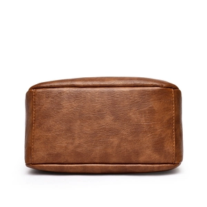Bottom view of brown leather handbag featuring large capacity and reinforced stitching details