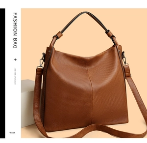 Dettaglio borsa shopper marrone con traforatura laser e design a doppia tracolla