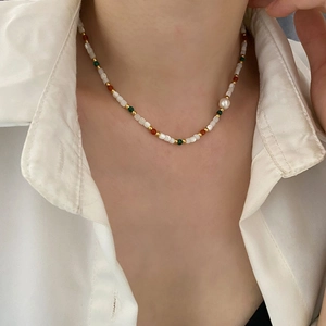 Handmade freshwater pearl necklace with colorful beads on a white shirt model