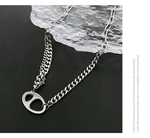 Détail du collier en acier titane argenté avec un pendentif à maillon ovale évidé