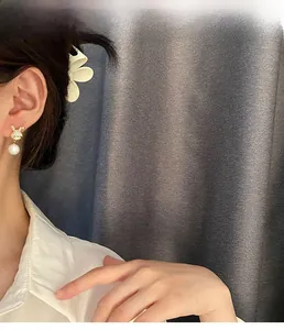 Détail de boucles d'oreilles lapin en or avec perle blanche portées par un mannequin