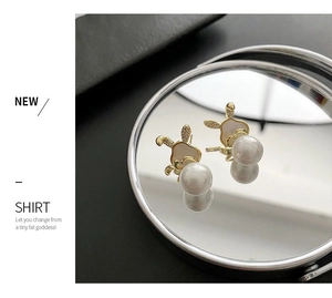 Détail macro de boucles d'oreilles lapin dorées avec zircon et perle sur miroir