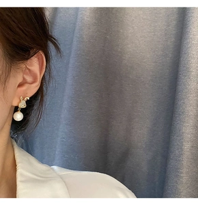 Détail de la boucle d'oreille lapin en perle avec tête dorée et incrustation nacre
