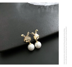 Vue macro de boucles d'oreilles lapin doré avec détails en zircon et perles blanches