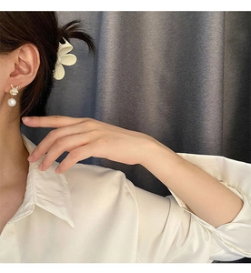 Détail de boucles d'oreilles lapin et perle avec zircon sur un modèle élégant