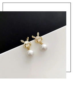 Détail de boucles d'oreilles lapin avec oreilles en zircone et perles blanches