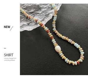 Detail of colorful stone beaded necklace with a baroque pearl and gold accents