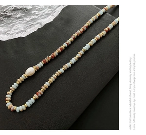 Close-up of beaded necklace with blue amazonite stones and a white baroque pearl