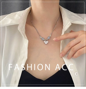 Détail du collier en argent avec pendentif cœur en zircon et perles bleues sur un mannequin