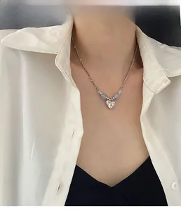Détail du collier cœur en argent avec perles bleues porté par un mannequin