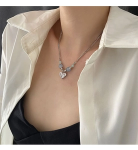 Détail d'un collier cœur en argent avec zircon et perles œil-de-chat bleues