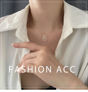 Détail du collier en bambou doré avec pendentif en jade blanc porté sur le cou