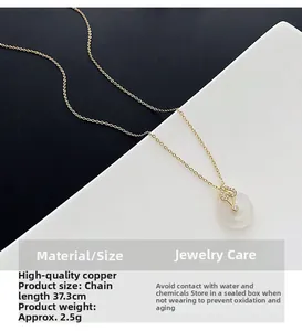 Détail du pendentif goutte d'eau sur chaîne dorée avec monture en zircon ajourée