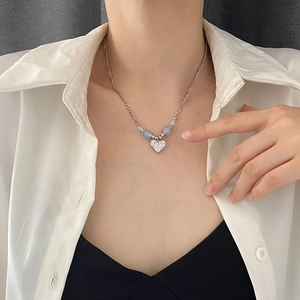 Collier élégant avec pendentif cœur, chaîne argentée et perles en zircone sur modèle