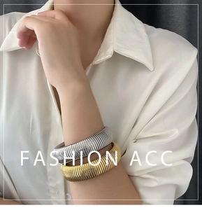 Detailed view of gold and silver ribbed stainless steel wide elastic bangle bracelets