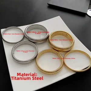 Detailed set of textured titanium steel bangles in gold and silver with various widths