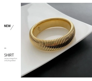 Detailed macro shot of a wide gold textured bangle with horizontal ribbed surface