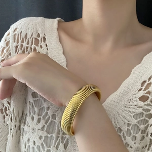 Polished gold wide threaded spring bracelet for women in a vintage minimalist style