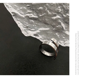 Macro detail of silver rotating ring engraved with I AM STRONG text on matte background