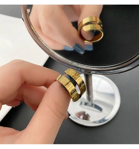 Detailed view of golden stainless steel wrap ring with 'STRONGER' engraving detail