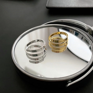 Polished gold and silver spiral rings with I AM STRONGER engraving on mirror surface