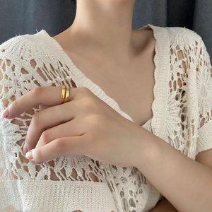 Minimalist double layer golden titanium steel ring worn on hand with crochet top background