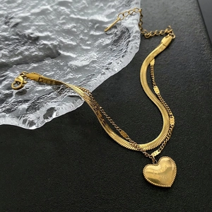 Detail of double-layer gold titanium steel bracelet with engraved Love You heart pendant