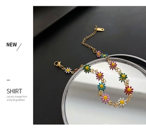 Detailed shot of a colorful daisy charm bracelet with gold-plated link chain and lobster clasp