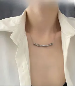 Dettaglio della collana con pendente irregolare stile metallo liquido su modella