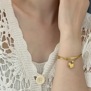 Double layer gold titanium steel bracelet with heart pendant on female wrist
