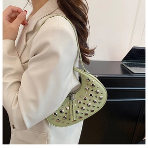 Detail of mint green crescent bag with silver studs on textured leather finish