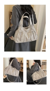 Detail of grey lychee pattern tote bag with decorative zippers and adjustable straps