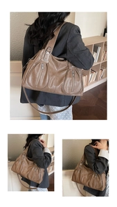 Detailed view of brown tote bag with vertical zip pockets and silver-tone hardware accents