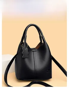 Gros plan du sac à main noir en cuir litchi avec logo kangourou et bandoulière amovible