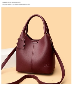 Vue détaillée de la texture grain litchi bordeaux et du logo kangourou du sac