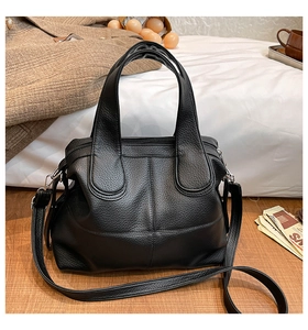 Detailed view of black litchi texture leather handbag with sturdy top handles and large capacity