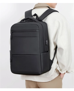 Close-up of black waterproof business backpack with external USB port on model back