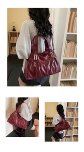 Detail view of large dark red tote bag featuring lychee texture and silver zipper pockets