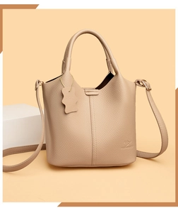 Détail du sac seau beige en cuir à motif litchi avec logo kangourou gaufré élégant
