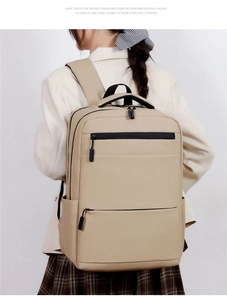 Detail view of beige business backpack with multiple compartments on a model's back